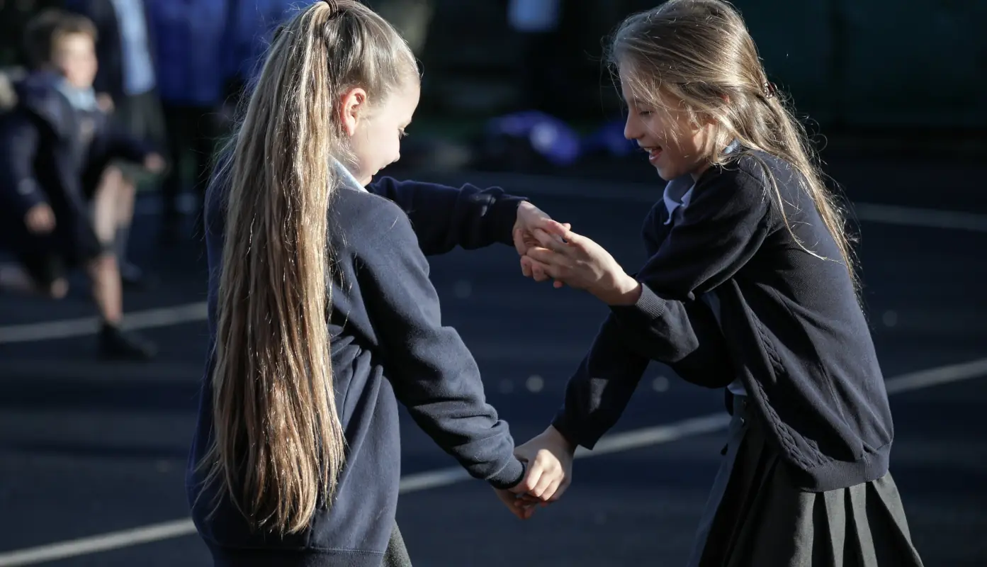 Mobberley Primary School children running and holding hands in the playground
